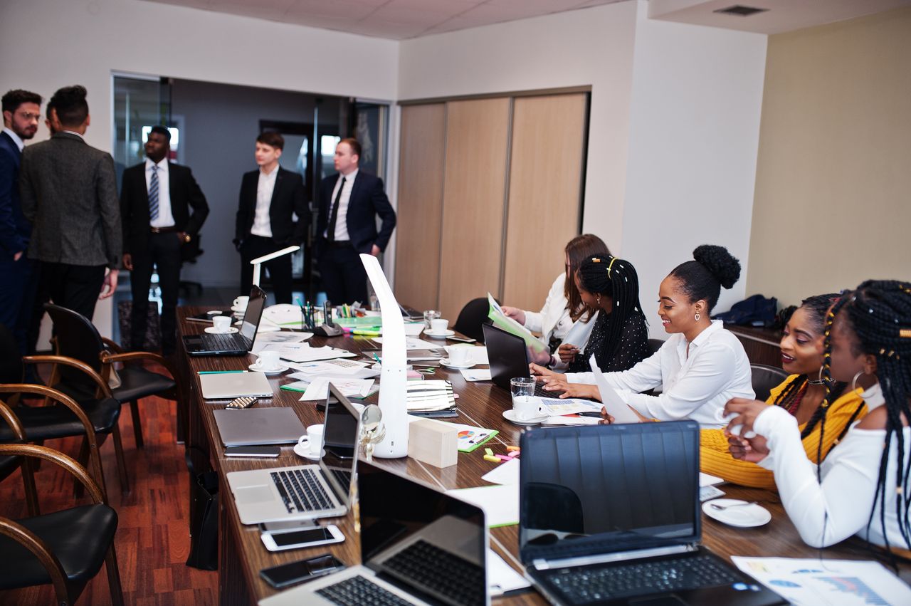 Équipe multiculturelle en réunion stratégique : méthodes et bonnes pratiques pour déployer initiatives locales à fort impact.